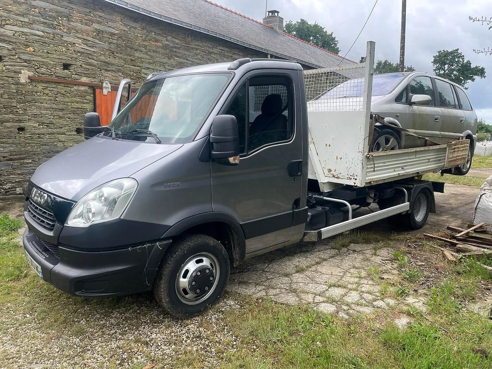 Le camion de Darel Services devant une longère, une voiture dans la benne